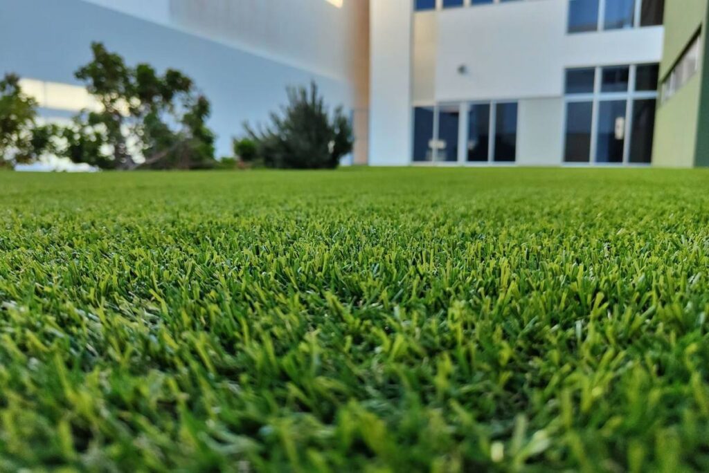 Primer plano de la fibra del césped artificial de Flor & Design