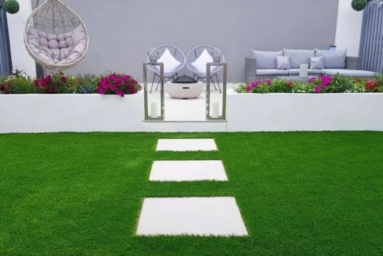Terraza con césped artificial, losas y muebles de exterior
